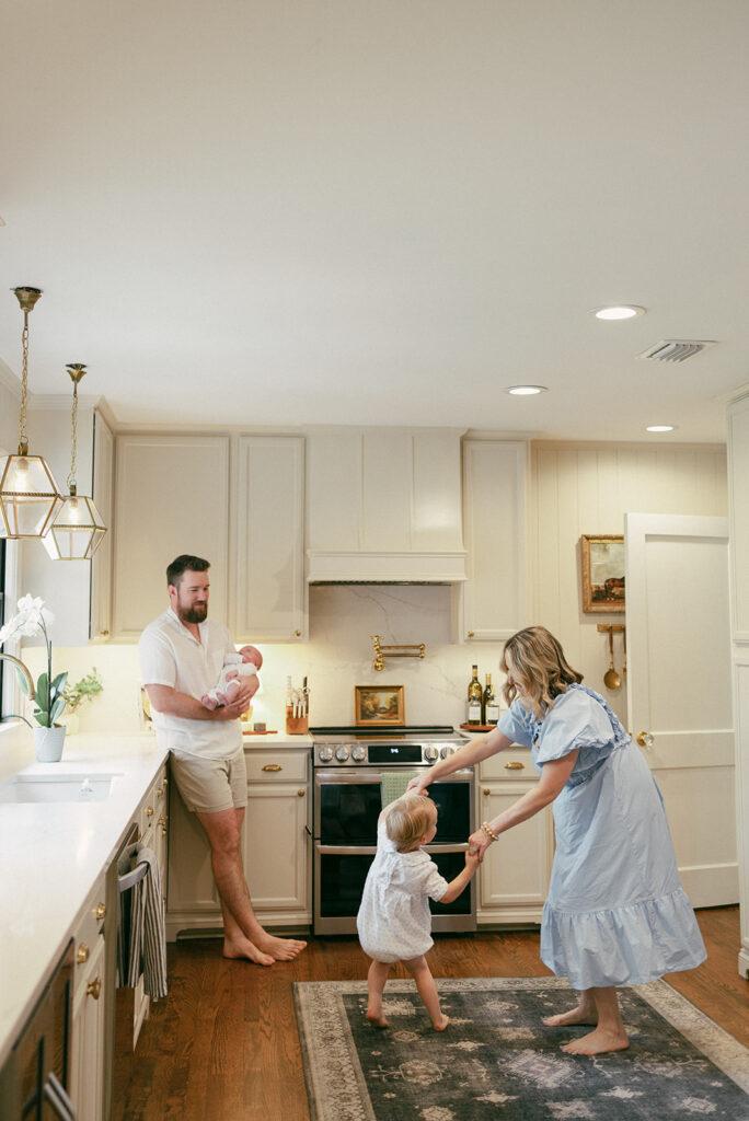 Jacksonville newborn family dancing in the kitchen as they celebrate the newest addition.