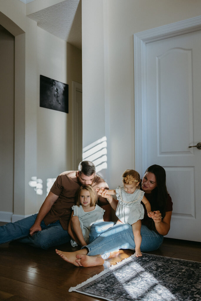 family of four spending time together on the floor in their jacksonville, florida home