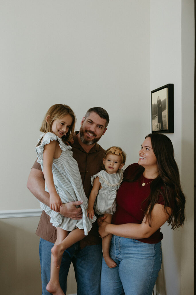 family of four standing together laughing in their jacksonville, florida home.