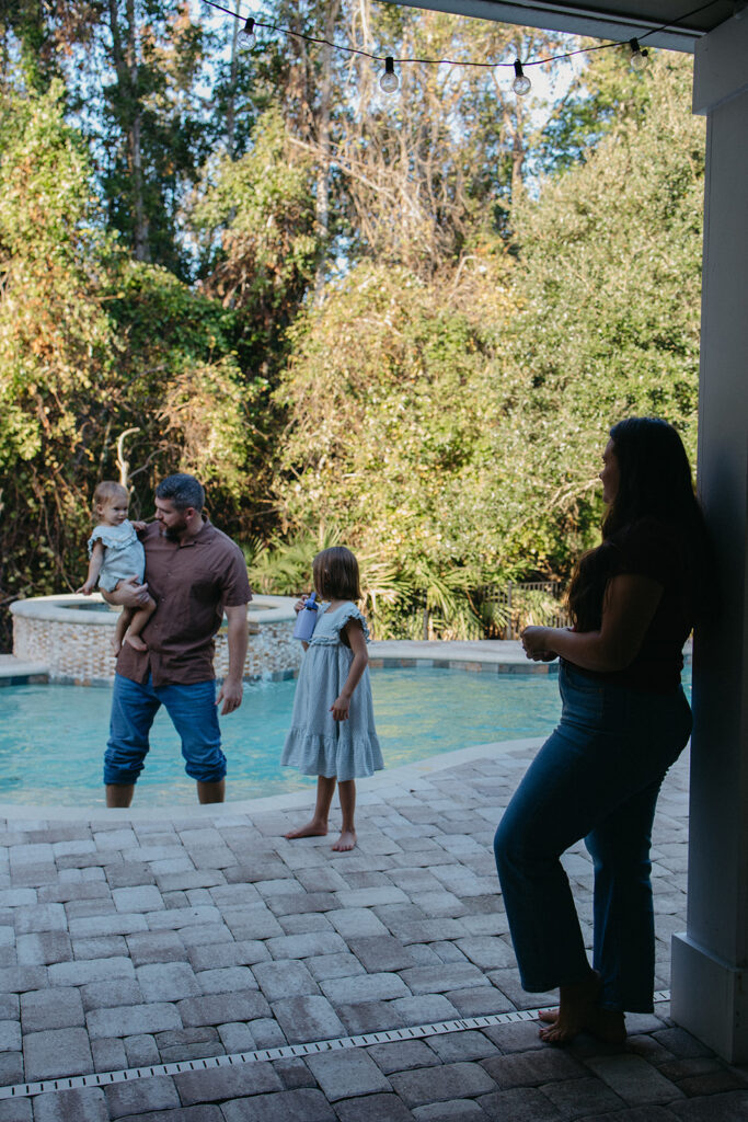 family of four standing together in the backyard of their jacksonville, florida home.