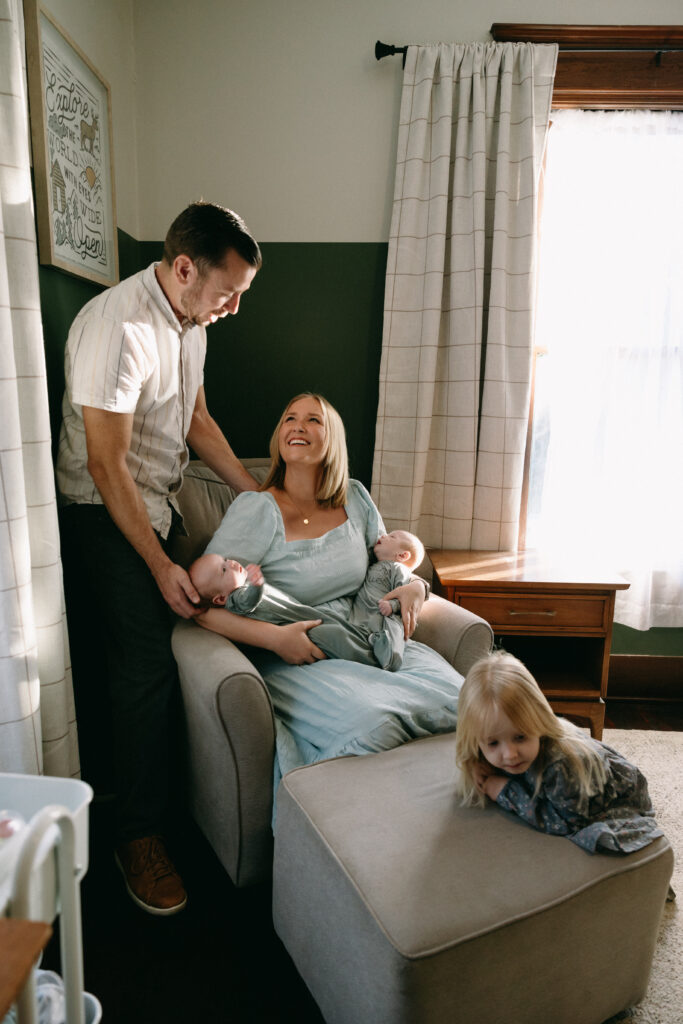 jacksonville fl family sitting in the nursery admiring baby twins together