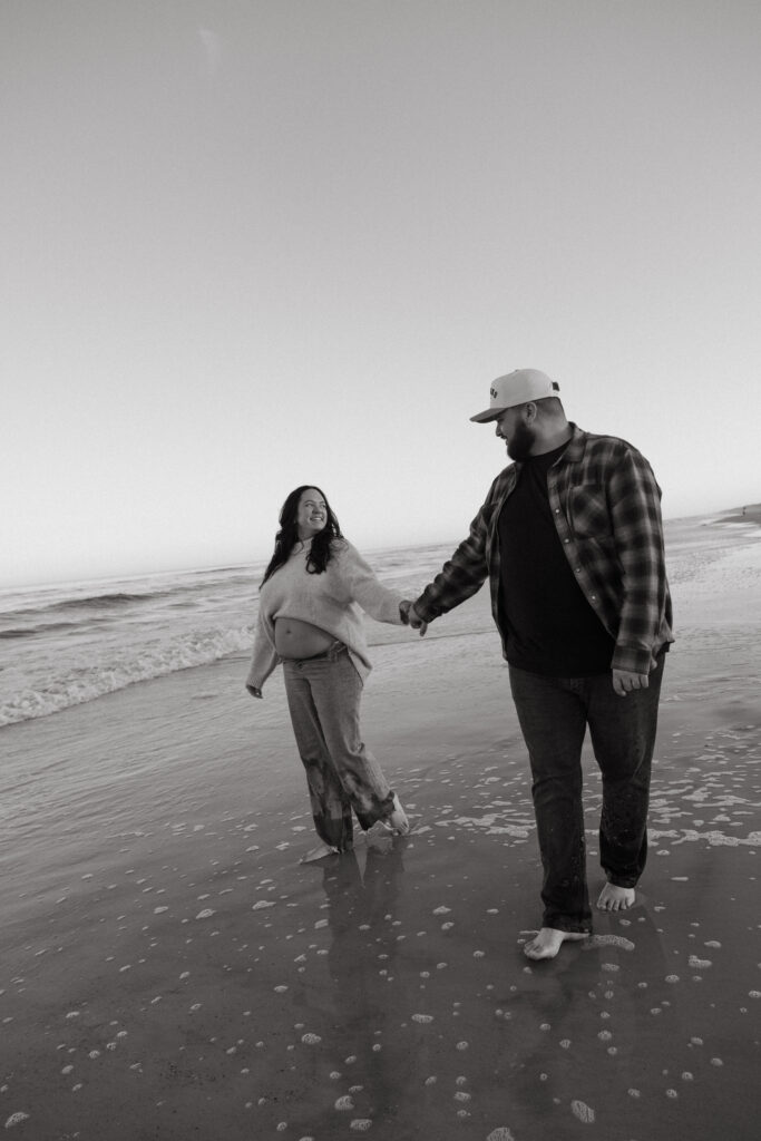 Pregnancy announcement photos in Jacksonville, Fl. Expecting parents walking on the beach