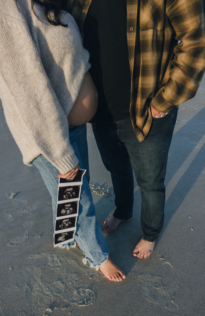 Pregnancy announcement photos in Jacksonville, Fl. Couple standing next to each other, holding ultrasound pictures