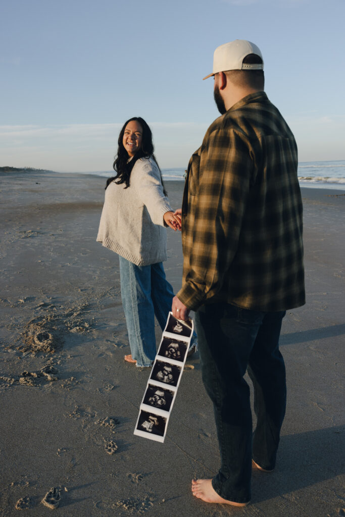 Pregnancy announcement photos in Jacksonville, Fl. Expecting parents looking at each other while holding ultrasound pictures