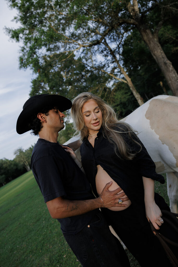 couple posing with a horse for an editorial maternity photoshoot