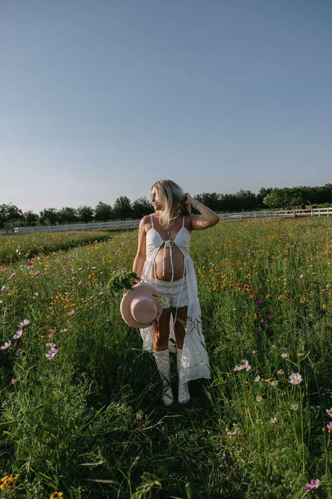 expecting mom standing in the flower fields at Congaree and Penn  for her maternity photo session.
