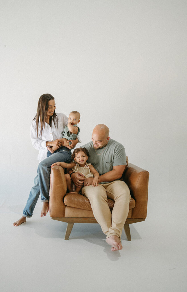 family sitting together on a chair in a jacksonville fl studio