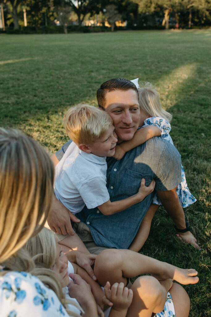 family sitting together in the grass at a jacksonville park