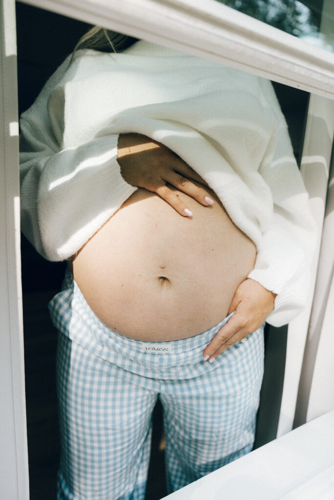 jacksonville maternity photographer captures a pregnant belly in a window